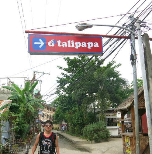 Evan standing under d'talipapa sign
