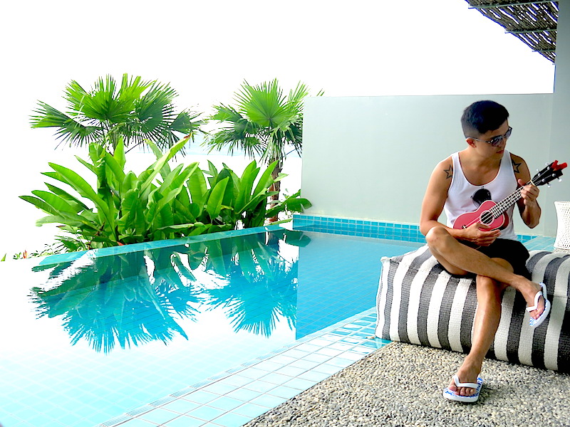 Evan playing ukelele by the pool