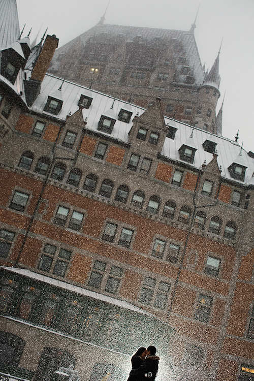 Couple kissing in front of Fairmont Le Chateau Frontenac